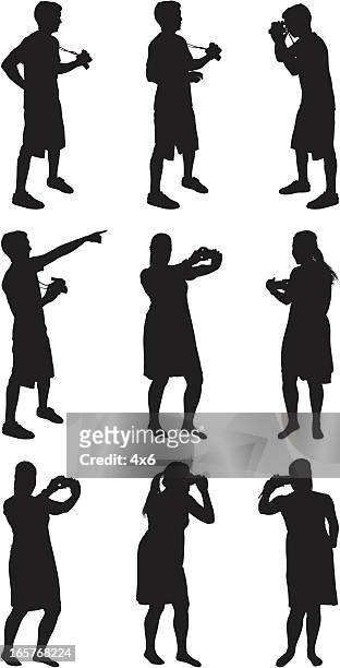 male and female silhouettes with cameras taking pictures - point and shoot camera stock illustrations