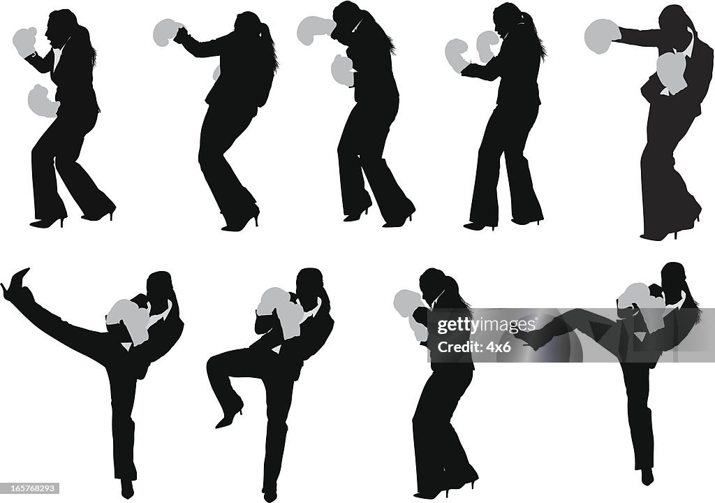 Businesswoman kick boxing in pant suit