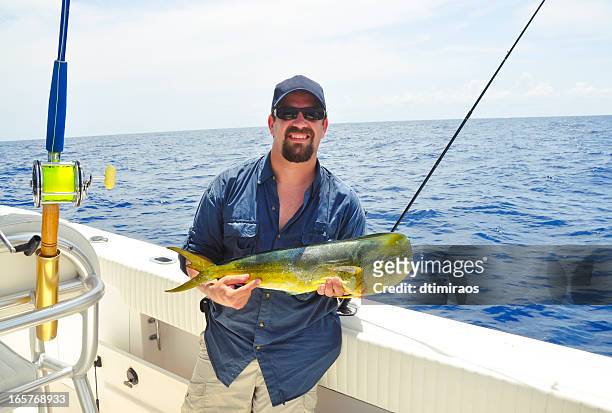 angler showing off his catch - deep sea fishing stock pictures, royalty-free photos & images