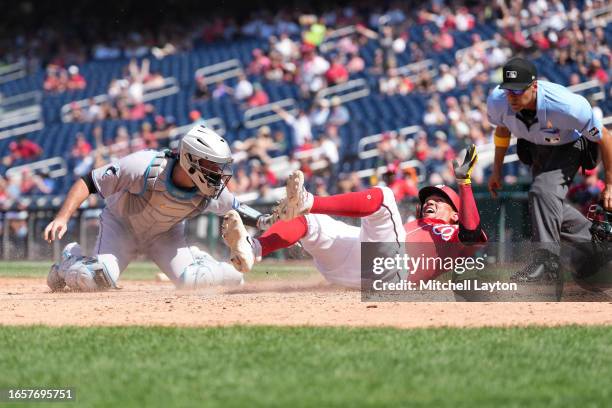 Ildemaro Vargas of the Washington Nationals beats the tag by Jacob Stallings of the Miami Marlins to score inn the nning during a baseball game at...