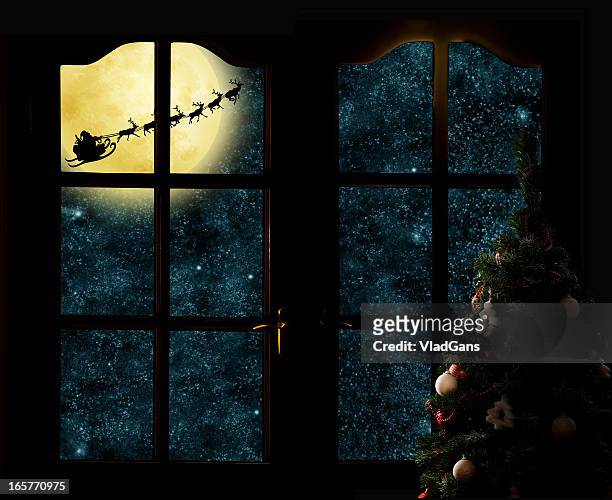 santa claus in his deer sled near the moon - christmas window stock pictures, royalty-free photos & images