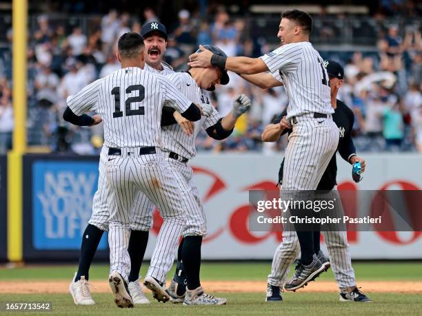 Kyle Higashioka of the New York Yankees is congratulated by his teammates after hitting a walk-off double to defeat the Milwaukee Brewers by 4-3 in...