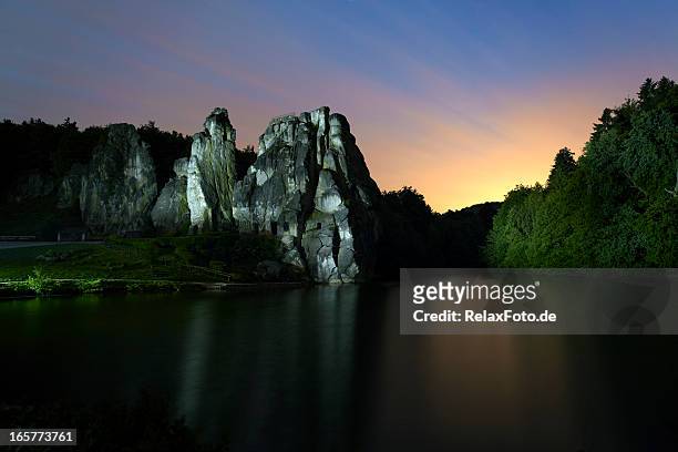 illuminato rock al tramonto-externsteine in nordreno-vestfalia - nordreno vestfalia foto e immagini stock