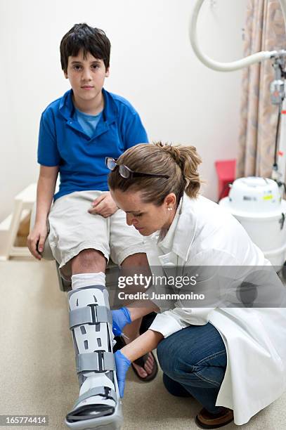 krankenschwester anpassen orthopädischer stiefel für kinder - doctor patient cast stock-fotos und bilder