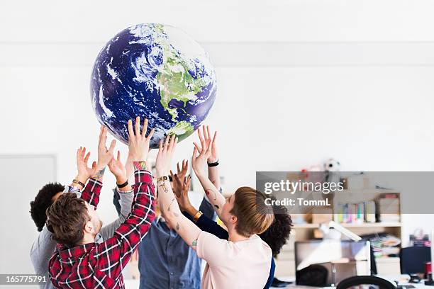 negócios jovem equipa jogar com globo de terra - holding globe imagens e fotografias de stock