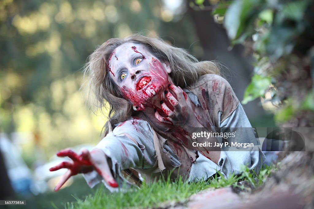 Zombie woman on the grass lawn reaches forward