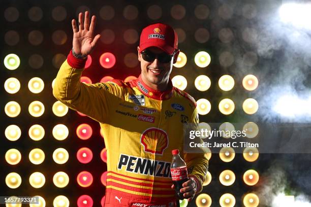 Joey Logano, driver of the Shell Pennzoil Ford, waves to fans as he walks onstage during driver intros prior to the NASCAR Cup Series Cook Out...