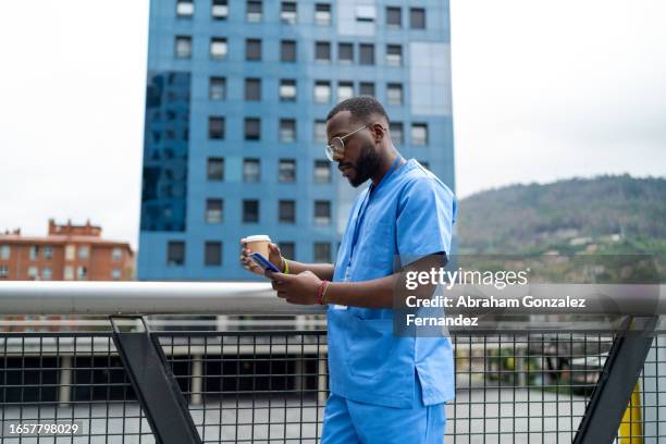african doctor using phone during a coffee break - man reading card stock pictures, royalty-free photos & images