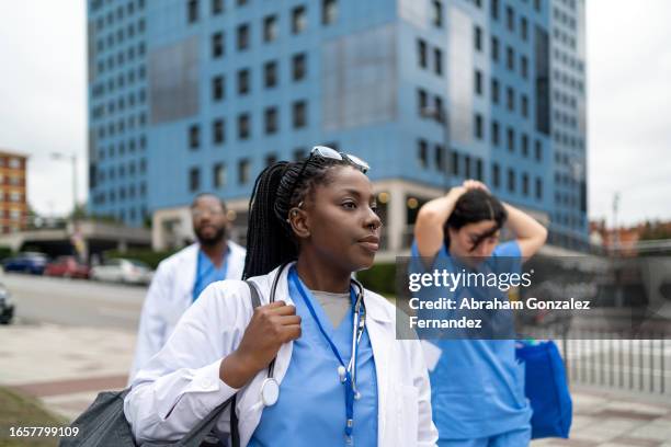 medical workers serious and tired finishing the shift going home - serviços-essenciais imagens e fotografias de stock