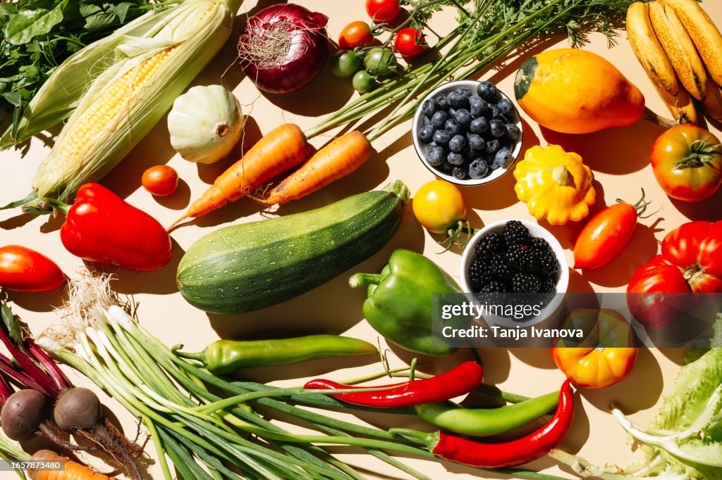 Variety fresh of organic fruits and vegetables on beige background. Healthy food, clean eating, diet and detox concept . Flat lay, top view