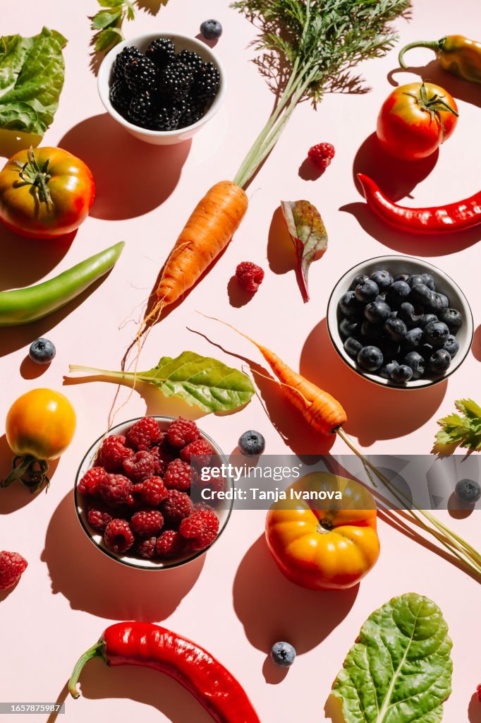 Pattern of variety fresh of organic berry fruits and vegetables and healthy vegan meal ingredients on pink background. Healthy food, clean eating, diet and detox, eco friendly, no plastic concept. Flat lay, top view