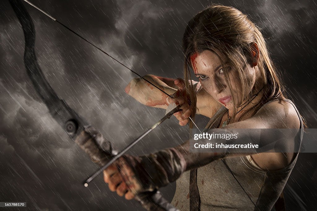 Weibliche Heldin mit Pfeil und Bogen auf einer regnerischen Nacht