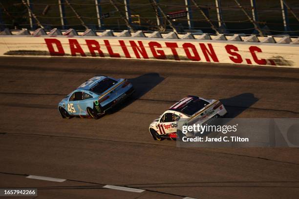 Tyler Reddick, driver of the Jordan Brand Toyota, and Denny Hamlin, driver of the Sport Clips Haircuts Toyota, race during the NASCAR Cup Series Cook...