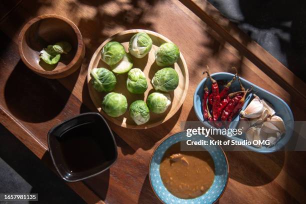brussels sprouts with other ingredients on the table - plastikbehälter stock-fotos und bilder