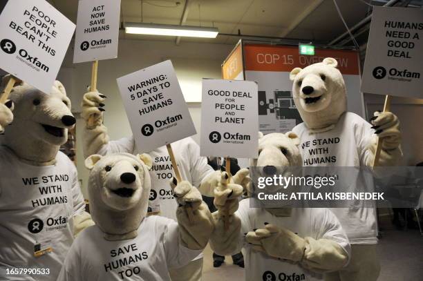 Activists wear ice polar bear costumes, as they prepare for the demonstration 'Save humans too' in the Bella center of Copenhagen on December 14,...