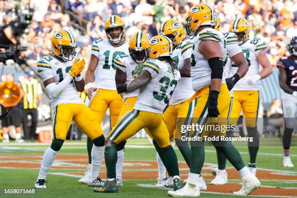 Running back Aaron Jones, quarterback Jordan Love and wide receiver Dontayvion Wicks of the Green Bay Packers celebrate during an NFL football game...