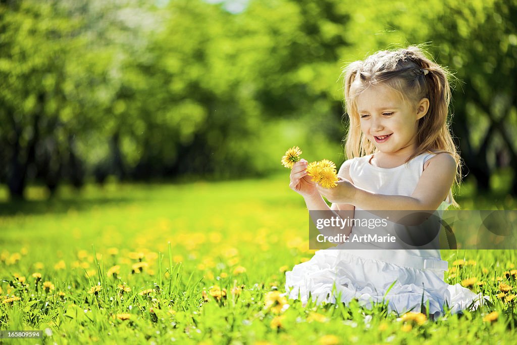 Little Girl Sitting On A Fielf Od Fandelions High-Res Stock Photo ...