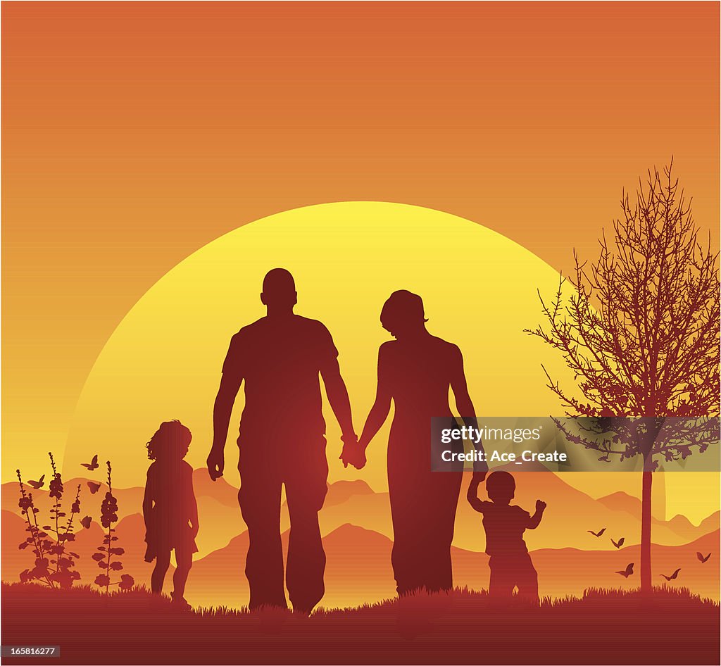 Young family walking in silhouette during a beautiful sunset