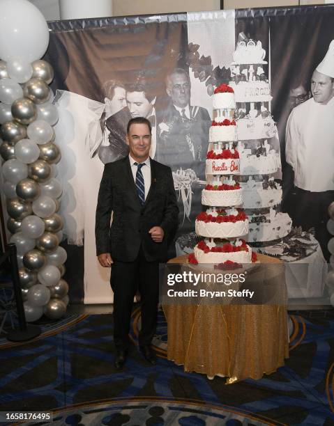 Actor Patrick Warburton poses with a six-tiered cake chef Christina Nasso made that was inspired by Elvis and Priscilla Pressley's 1967 wedding cake,...