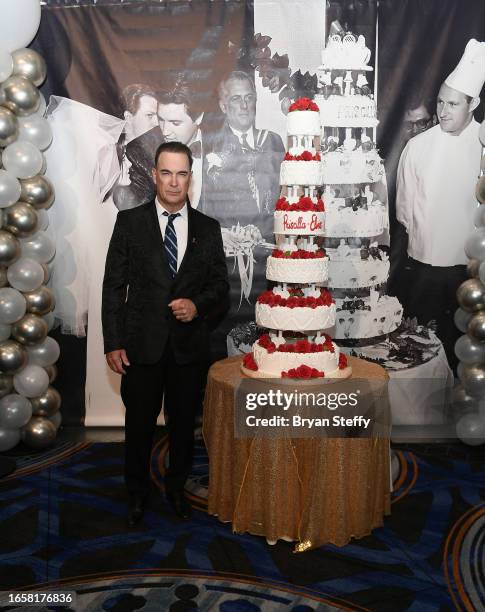 Actor Patrick Warburton poses with a six-tiered cake chef Christina Nasso made that was inspired by Elvis and Priscilla Pressley's 1967 wedding cake,...
