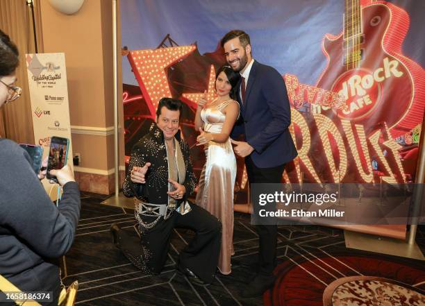 Elvis Presley impersonator Brian Mills poses for photos with Lucia Pabon and Chris Pabon of Germany before a wedding vow renewal ceremony for nearly...