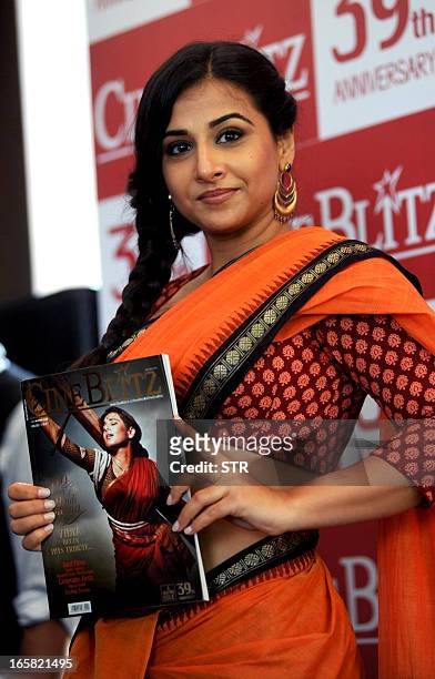 Indian Bollywood film actress Vidya Balan holds a copy of the Cine Blitz magazine featuring herself as "Mother India" during the unveiling of the...