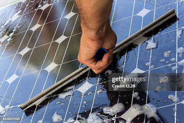 cleaning solar panel with window cleaner - solpanel bildbanksfoton och bilder