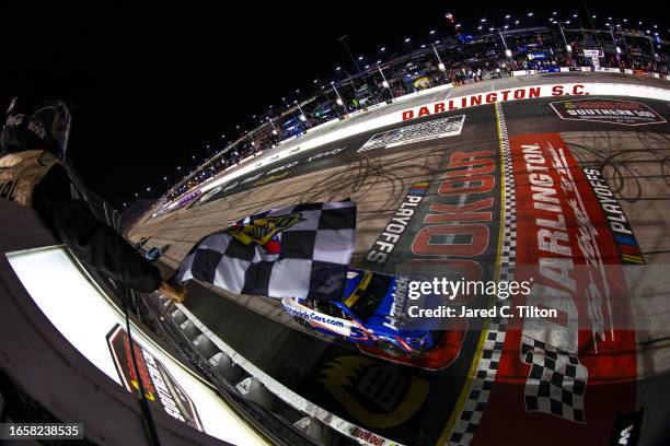 Kyle Larson, driver of the HendrickCars.com Chevrolet, takes the checkered flag to win the NASCAR Cup Series Cook Out Southern 500 at Darlington...