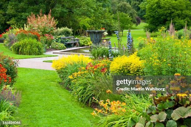 flowerbeds, lawn and pond in a beautiful park - garden pond stockfoto's en -beelden