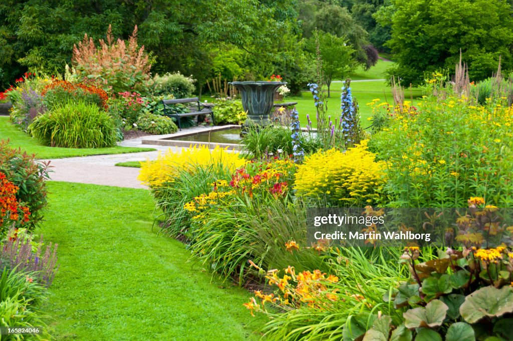 Flowerbeds, lawn and pond in a beautiful park