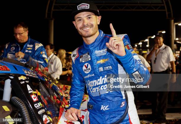 Kyle Larson, driver of the HendrickCars.com Chevrolet, poses with the winner sticker on his car in victory lane after winning the NASCAR Cup Series...