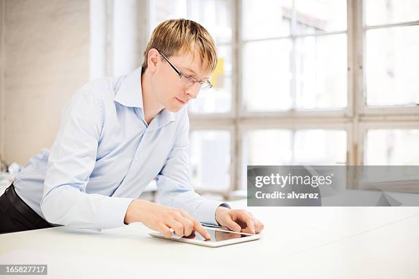 homem trabalhando em um tablet digital - só um adulto de idade mediana - fotografias e filmes do acervo