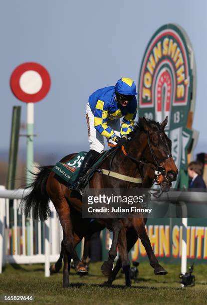 Auroras Encore ridden by Ryan Mania crosses the line to win the John Smiths Grand National at Aintree Racecourse on April 6, 2013 in Liverpool,...