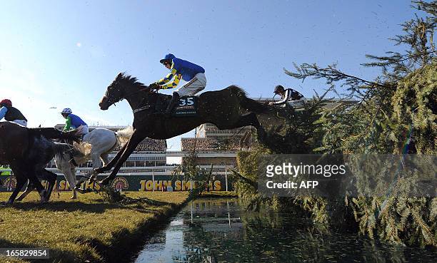 Auroras Encore ridden by Ryan Mania goes over the water jump during the Grand National horse race at Aintree Racecourse in Liverpool, north-west...