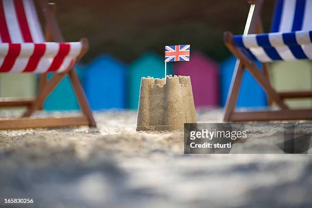 sandcastle with uk flag between two deck chairs - british culture stock pictures, royalty-free photos & images