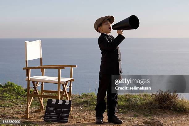 little réalisateur crier sur porte-voix dans l'ensemble en plein air - réalisateurs films photos et images de collection