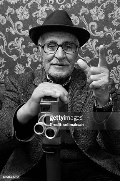 senior old style videographer posing with his video camera - film director stock pictures, royalty-free photos & images