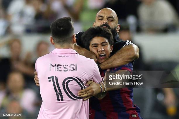 Yassine Chueko, bodyguard of Lionel Messi of Inter Miami CF, pulls a fan, who ran onto the pitch, away from Messi in the second half during a match...
