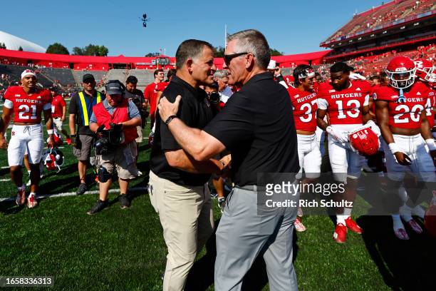Head coach Greg Schiano and Athletic Director Pat Hobbs of the Rutgers Scarlet Knights shake hands after defeating Northwestern Wildcats 24-7 in a...