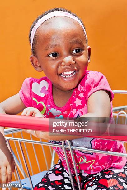 little african girl on a shopping trolley - alice band stock pictures, royalty-free photos & images