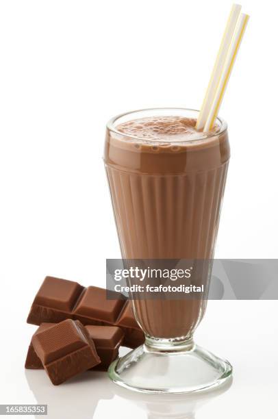 glass of chocolate milkshake with chocolate chunks on white - chocolate smoothie stock pictures, royalty-free photos & images