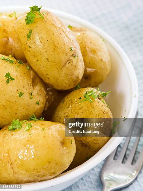 close-up of boiled potatoes in a bowl with herbs - gekookte aardappel stockfoto's en -beelden