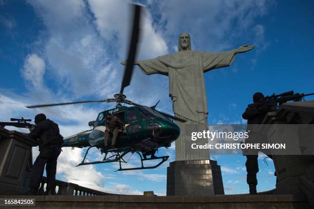 The Elite Unit of the Brazilian Military Police practice maneuvers in front of the Christ the Reedemer statue on Corcovado Hill in Rio de Janeiro,...