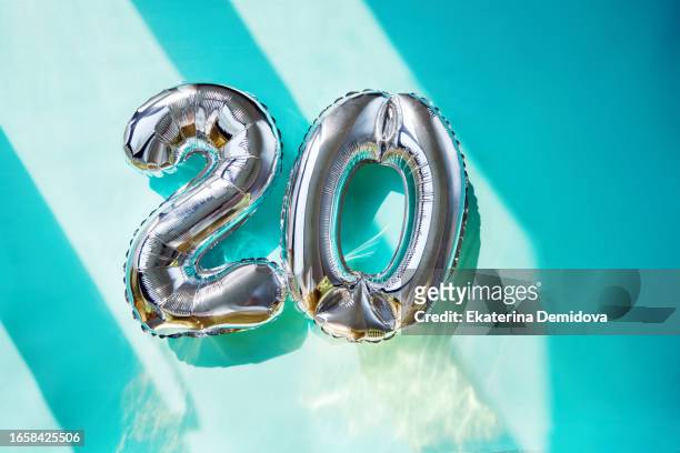 silver numbers 20 twenty years balloons in sunlight blue turquoise background - number 20 stock pictures, royalty-free photos & images