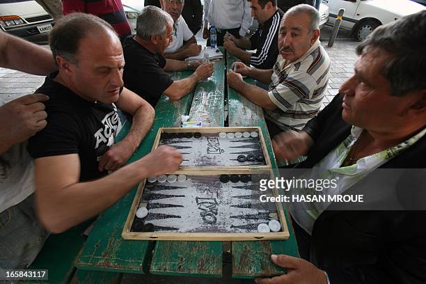 People play backgammon near the market place on April 6, 2013 in the Cypriot capital, Nicosia. AFP PHOTO/HASAN MROUE