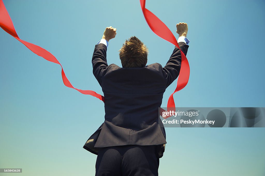 Businessman Winning Success Outdoors at Red Finish Line Blue Sky