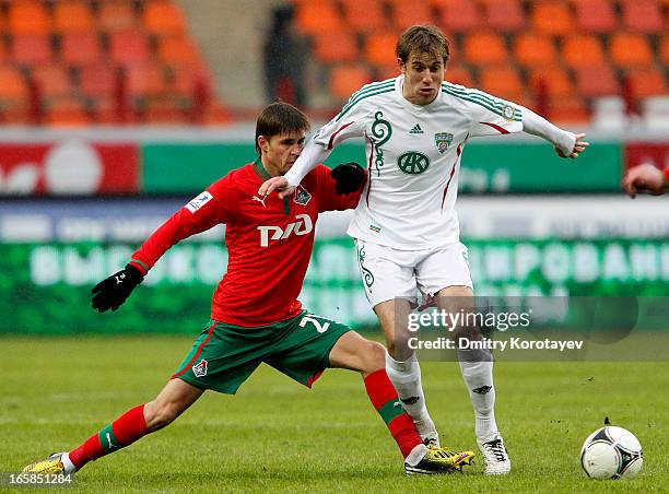 Dmitri Torbinski of FC Lokomotiv Moscow is challenged by Adilson of FC Terek Grozny during the Russian Premier League match between FC Lokomotiv...
