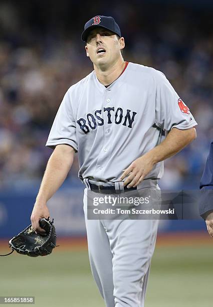 John Lackey of the Boston Red Sox exits the game in the fifth inning due to an injury to his pitching arm during MLB game action against the Toronto...