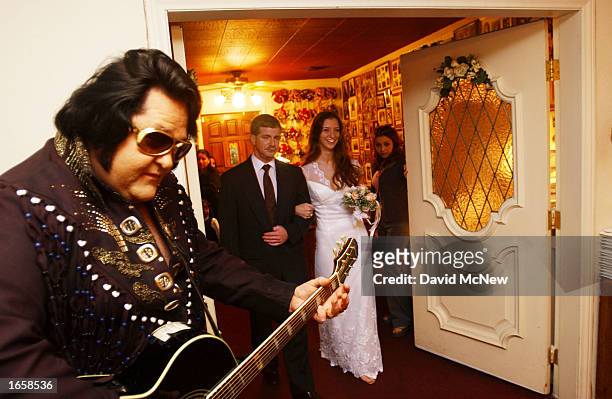 Elvis Presley impersonator Norm Jones plays guiter as Bruce Barnett, of Virginia Beach, Virginia, escorts his daughter Gayle to her wedding ceremony...