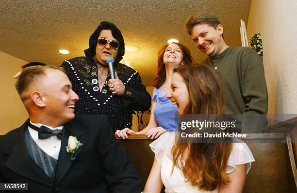 Alex Carlson , a Marine from Twentynine Palms Marine Base, California, and his bride Gayle Barnett laugh as Elvis Presley impersonator Norm Jones...